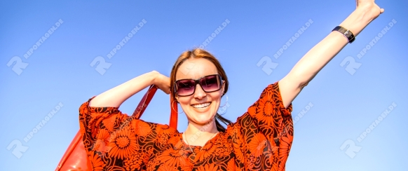 Young beautiful woman with red bag standing.