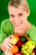 Healthy lifestyle - woman with fruit shopping paper bag on green background