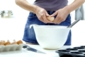 Female hands breaking eggs into a bowl.�