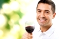 profession, drinks, leisure, holidays and people concept - happy man drinking red wine from glass over green background