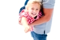 Close-up of little girl enjoying piggyback ride with her father against a white background