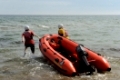 Rettungsschwimmer ziehen schnell das Schlauchboot ins Wasser
