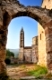 Image shows an old historic church in the town of Kardamili, southern Greece, framed by an old arch 